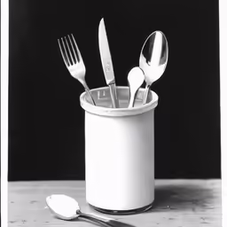 silverware in a cup is kept in the bottom one is filled with forks