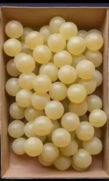 a box filled with white balls on top of a table