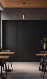 a black wall and a wooden table inside a room