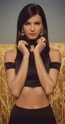 a woman wearing black lingerie and jewelry stands in a field