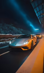 four fancy cars parked on a city street at night
