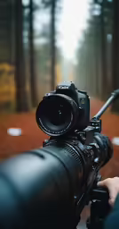 person holding a camera looking through a telescope