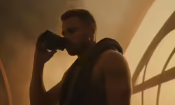 a man looking into a camera with smoke coming out