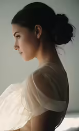 a woman is sitting wearing a white dress