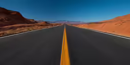 long straight asphalt road with yellow lines in between red mountains