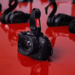 camera attached to a red surface, on which is several other camera parts