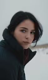 a woman in a jacket is looking off into the distance