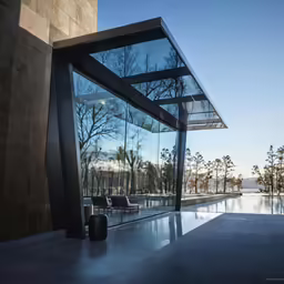 an empty courtyard with large glass doors and furniture