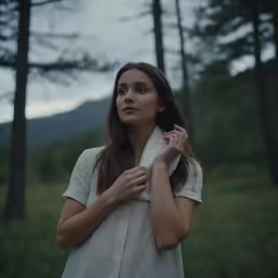 a woman with long hair posing in a forest