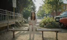a person sitting on top of a bench in the street