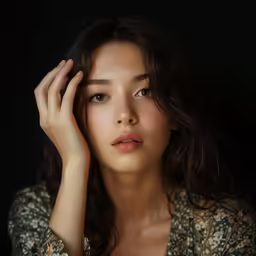 a young woman poses for the camera with one hand on her head