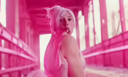pink haired woman poses in an industrial facility