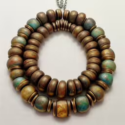 a necklace has many different colors and shapes,the brown and green beads are tied to silver chains,a bracelet with several different shapes and colors on it,a necklace is made of small wooden beads,bracelet made of wood and beads with different colors
