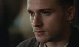 a man with brown eyes is staring straight ahead