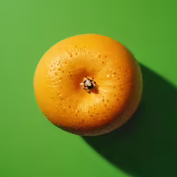 a ripe orange sitting on top of a green table