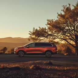 a very long red suv parked on the road