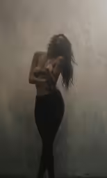 a naked lady is posing on the beach in the fog
