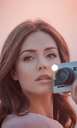 a woman holding up an electronic device to her face