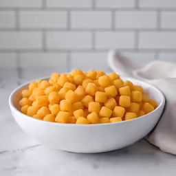 a white bowl filled with a tiny cut up carrot