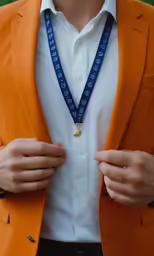 a close up of a person in a suit tying a medal