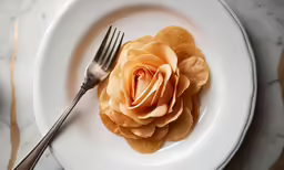 an edible flower is on a white plate with silverware