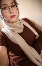 woman with glasses and scarves sitting on a couch