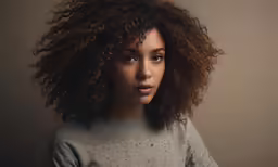 woman with full hair and brown shirt in the studio