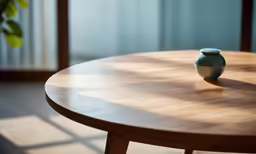 a green vase on top of a wooden table