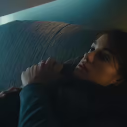 a person sitting on a couch holding a remote