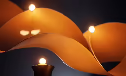 two lit candles are placed in between a decorative sculpture and each one