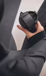 a person in a suit holding a cell phone