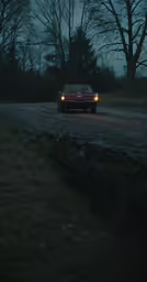 car driving down the road at night under a full moon