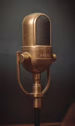 a gold microphone on a black and gray background