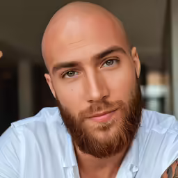 a bald man in a white shirt posing for a photo