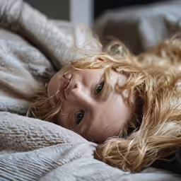 a young woman lays down on a bed