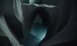 dark curves of a concrete tunnel with a light in the middle