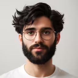 a man with a beard wearing glasses looking straight ahead