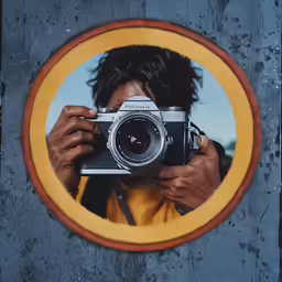 person taking photo of photograph with old camera