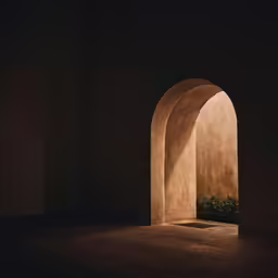an archway in a dark room leading into another room