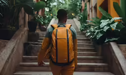 a young man is carrying his schoolbag down the stairs
