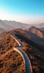 a winding road in the hills leading into a mountain range
