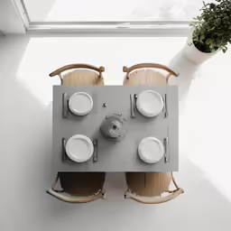 top view of wooden chairs and a table with dishes on top