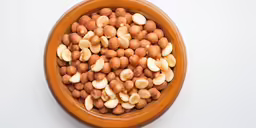a wooden bowl filled with nuts sitting on top of a white counter