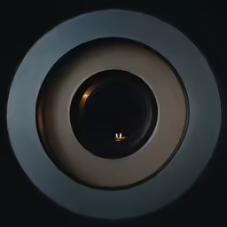 a lit candle is inside of a round black object