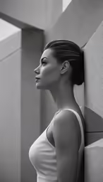 the girl is standing near the wall with her back to the camera