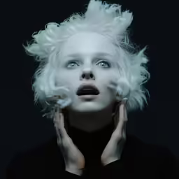 the woman with white hair and blue eyes has frizzy white hair