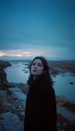 a woman wearing a coat looks at the sky