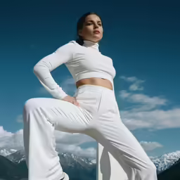 a woman in a white outfit poses for the camera