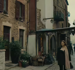 a woman standing on the sidewalk in front of a building