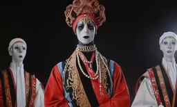 four dolls wearing black and white makeup standing together